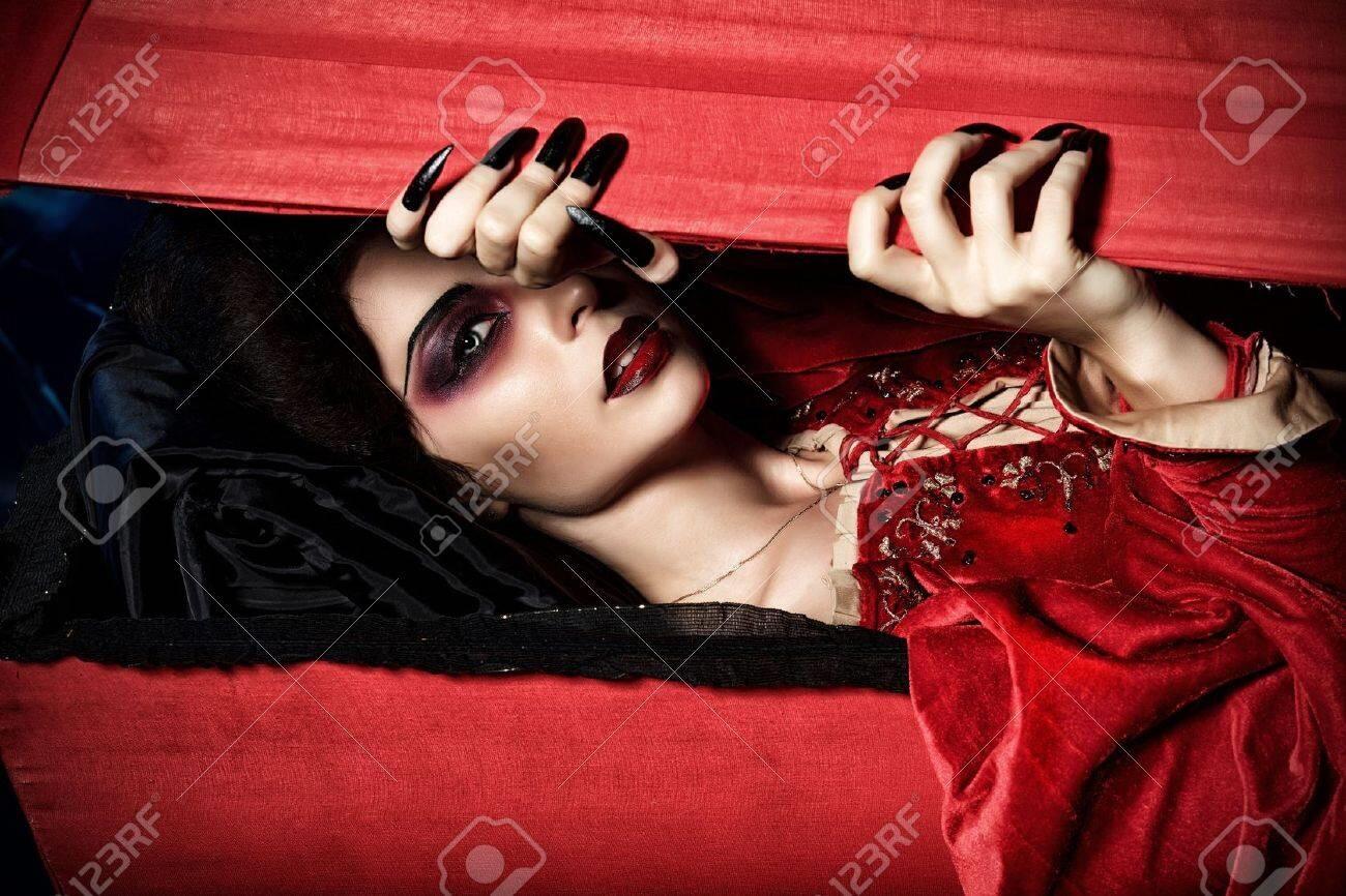  femme vampire assoiffé de sang monte du cercueil sur le cimetière de la nuit 